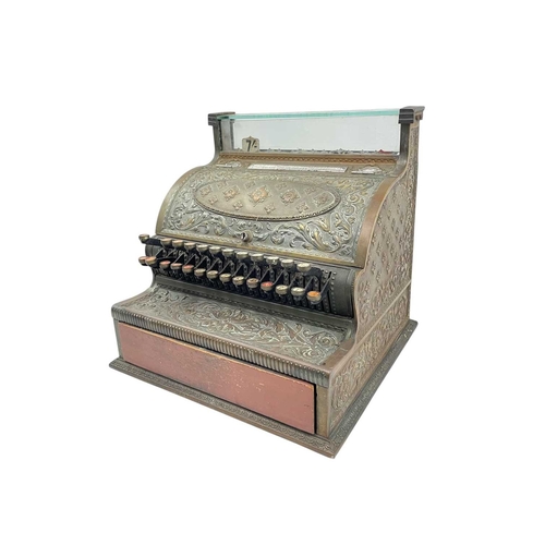 69 - A late 19th century American National cash register. In an ornate cast brass case, with applied labe... 