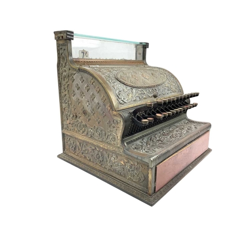 69 - A late 19th century American National cash register. In an ornate cast brass case, with applied labe... 