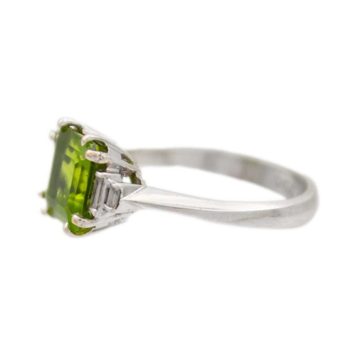 100 - A square emerald-cut peridot and diamond 18k white gold ring. The vivid green peridot is 7mm x 7mm a... 