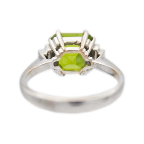 100 - A square emerald-cut peridot and diamond 18k white gold ring. The vivid green peridot is 7mm x 7mm a... 