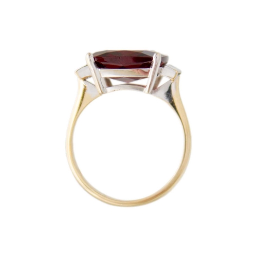 103 - A Rhodolite garnet and diamond 18k gold dress ring. The square cushion-cut purplish red garnet is 12... 