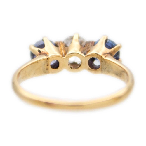 107 - A three-stone diamond and sapphire 18k yellow gold ring. The brilliant-cut white diamond is 0.30ct a... 