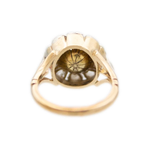 112 - An antique pearl and diamond cluster gold ring. A flower-shape design with rose-cut diamonds on peta... 