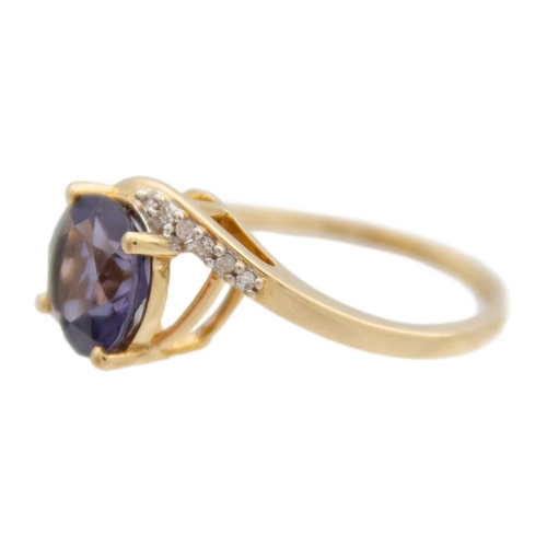 125 - A 9k gold blueberry quartz and diamond crossover ring. A purplish blue round mixed-cut quartz is 8mm... 