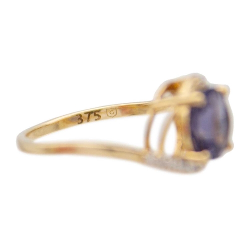 125 - A 9k gold blueberry quartz and diamond crossover ring. A purplish blue round mixed-cut quartz is 8mm... 