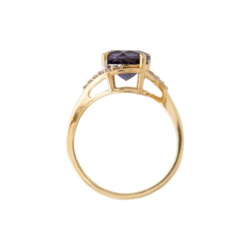 125 - A 9k gold blueberry quartz and diamond crossover ring. A purplish blue round mixed-cut quartz is 8mm... 