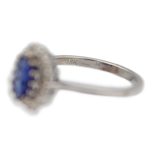 133 - An 18K white gold oval blue kyanite and diamond halo ring. Kyanite, 1.77ct, is surrounded by fourtee... 