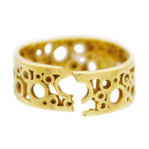 138 - An 18k openwork band ring by Tiffany & Co. The band formed with various sized open circles, hallmark... 