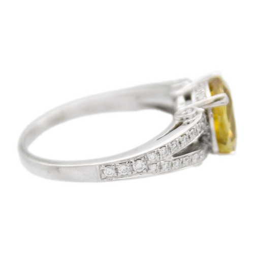 175 - A golden chrysoberyl and diamond platinum ring. The oval mixed-cut chrysoberyl is 8mm x 9mm, with ac... 