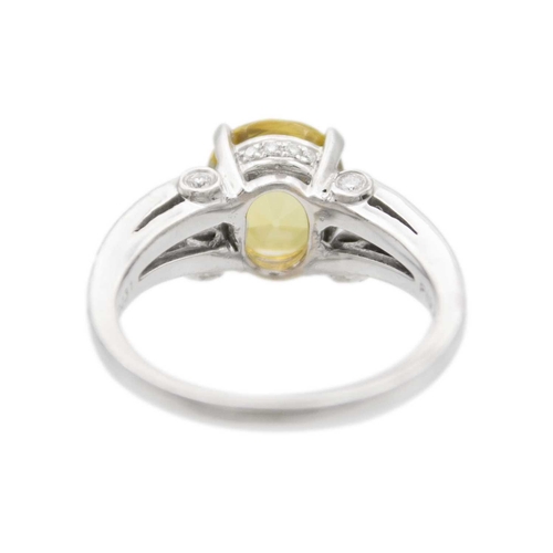 175 - A golden chrysoberyl and diamond platinum ring. The oval mixed-cut chrysoberyl is 8mm x 9mm, with ac... 