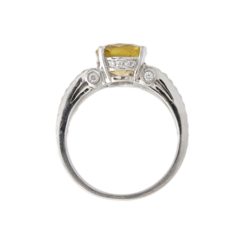 175 - A golden chrysoberyl and diamond platinum ring. The oval mixed-cut chrysoberyl is 8mm x 9mm, with ac... 