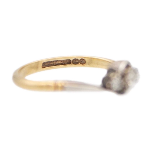 91 - An early 20th century 9k gold and platinum three-stone diamond crossover ring. The principal stone i... 