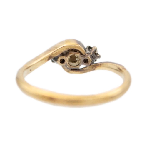 91 - An early 20th century 9k gold and platinum three-stone diamond crossover ring. The principal stone i... 