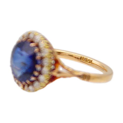 95 - An 18k rose gold synthetic blue sapphire and diamond set halo ring. The stone is approx 4.5ct (1cm i... 