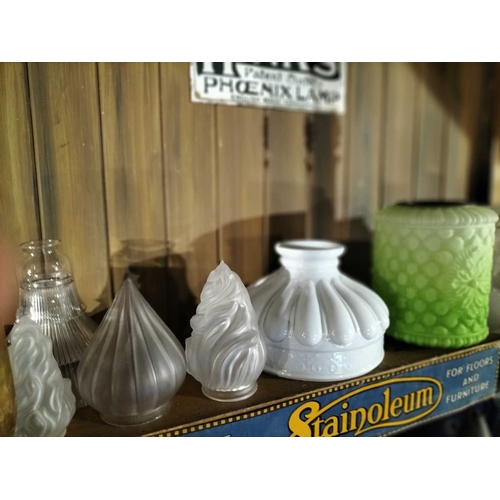 117 - ± Clemence's Ironmongers Glass lamp shades and oil lamp chimneys The top shelf contents to include m... 