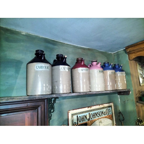 135 - ± Clemence's Ironmongers stoneware acid jars A good run of six stoneware acid jars each 34cm high to... 