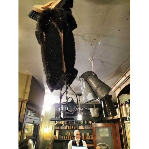 150 - ± Clemence's Ironmongers Tin ewers, egg pail etc A collection of items hanging from the shop ceiling... 