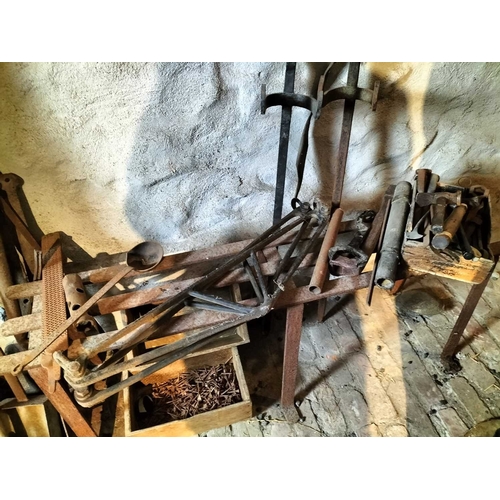 212 - ± Wiltshire & Son Blacksmiths ironwork A collection of ironwork including a bench, tools,horse shoes... 