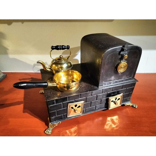 505 - ± Mr Neville's Toyshop Gebruder Bing manner, a tin and brass stove A toy stove with brass fittings p... 