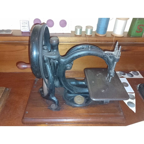 564 - ± K Fillingham Milliners Workshop Four Sewing Machines A Willcox and Gibbs treadle machine with lid,... 