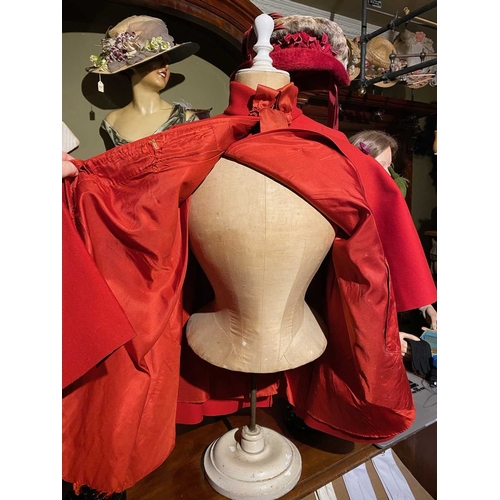 595 - ± K Fillingham Milliners Wool cape & mannequin In left hand shop window display, a red wool felt cap... 