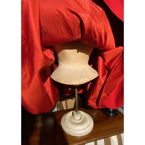 595 - ± K Fillingham Milliners Wool cape & mannequin In left hand shop window display, a red wool felt cap... 