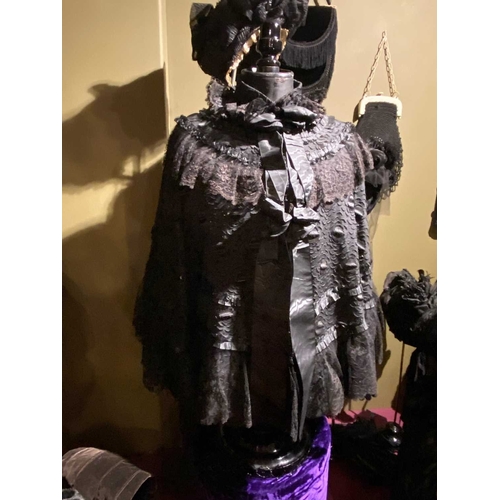 602 - ± K Fillingham Milliners Black fabric mannequin and cape A wasp waisted mannequin covered in black s... 