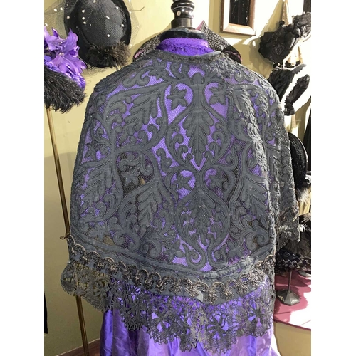 605 - ± K Fillingham Milliners A mannequin wearing a purple silk Victorian day dress A black fabric covere... 