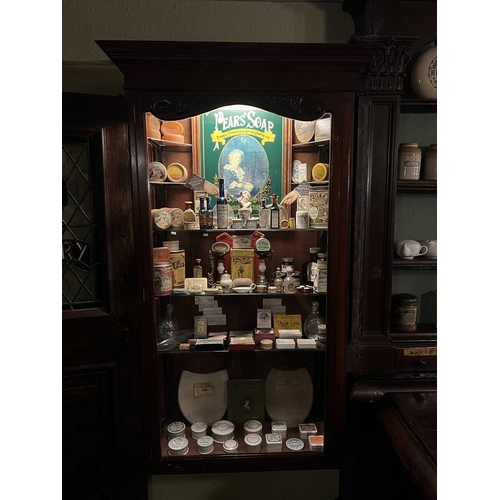 709 - ± J Dyke Apothecary Cabinet and Treasures A recessed cabinet with a locking glazed door and carved c... 