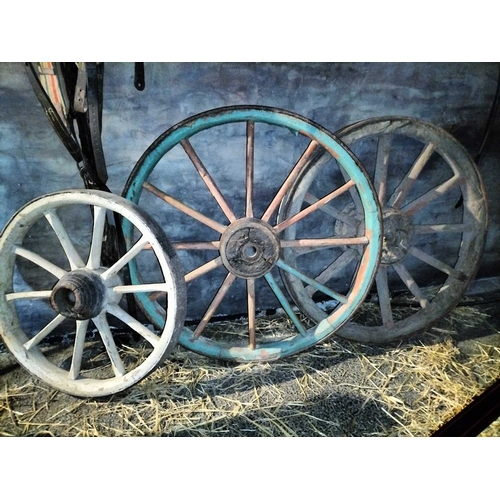 785 - ± Flambards Hotel and Coach House Three wagon wheels A group of three large old & odd wagon wheels l... 