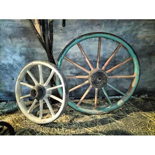 785 - ± Flambards Hotel and Coach House Three wagon wheels A group of three large old & odd wagon wheels l... 