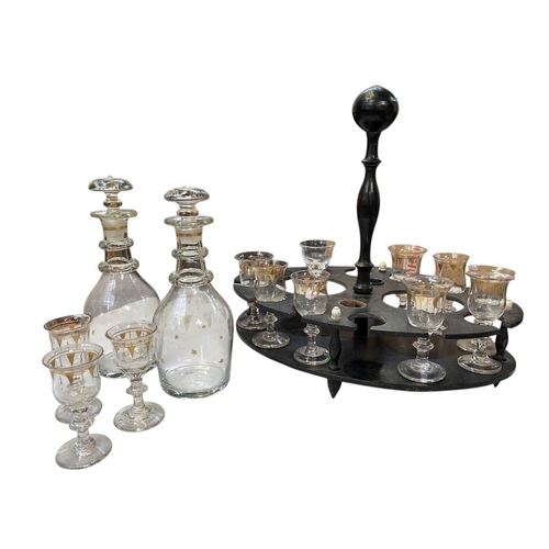 103 - A Victorian ebonised liqueur stand. Of oval section, with a turned handle and fitted two decanters a... 