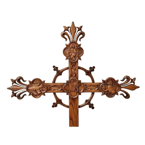 111 - A French carved oak wall mounted cross of fleur de lis form. Carved with 'IHS' to centre, surrounded... 