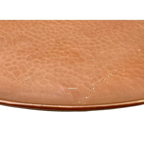 14 - A Newlyn copper large circular tray. With a planished finish, stamped mark, diameter 57cm.