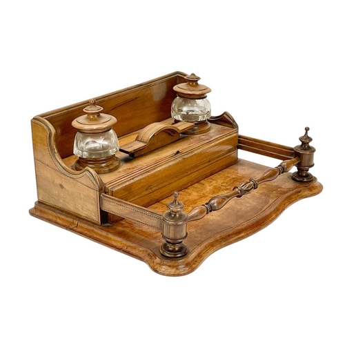 30 - A late Victorian olive wood desk stand. The two glass inkwells with turned covers, above two narrow ... 