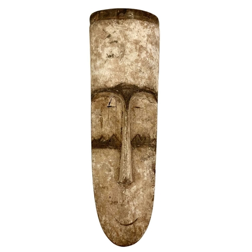 39 - Three carved wood African Fang masks. Of elongated form, all with white and black pigment, 46cm and ... 