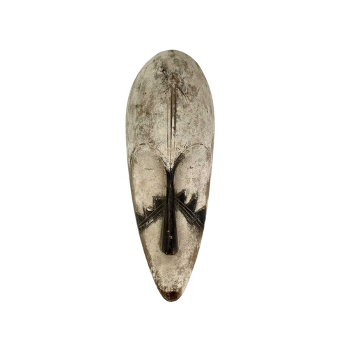 39 - Three carved wood African Fang masks. Of elongated form, all with white and black pigment, 46cm and ... 