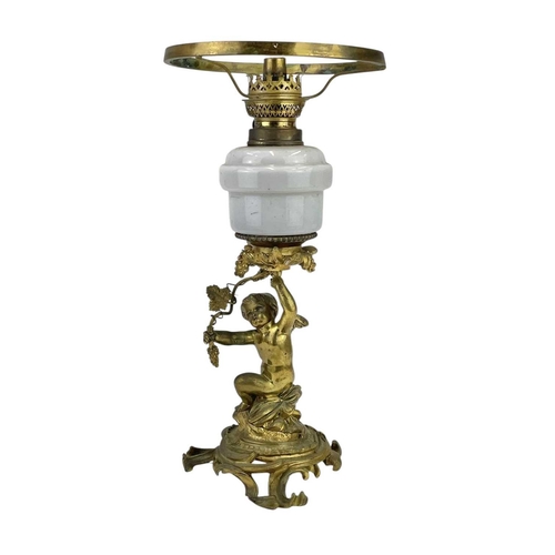 61 - A 19th century gilt brass cherub oil lamp. The opaque glass reservoir on a grape and vine base with ... 