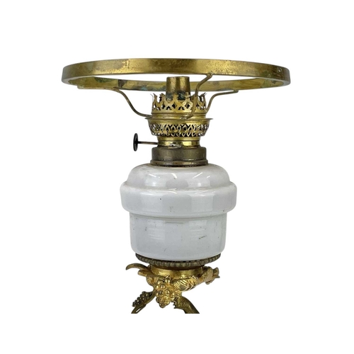 61 - A 19th century gilt brass cherub oil lamp. The opaque glass reservoir on a grape and vine base with ... 