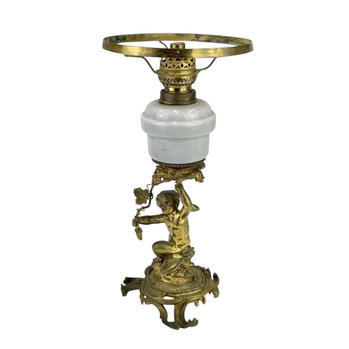 61 - A 19th century gilt brass cherub oil lamp. The opaque glass reservoir on a grape and vine base with ... 