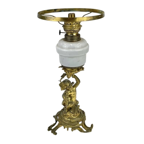 61 - A 19th century gilt brass cherub oil lamp. The opaque glass reservoir on a grape and vine base with ... 