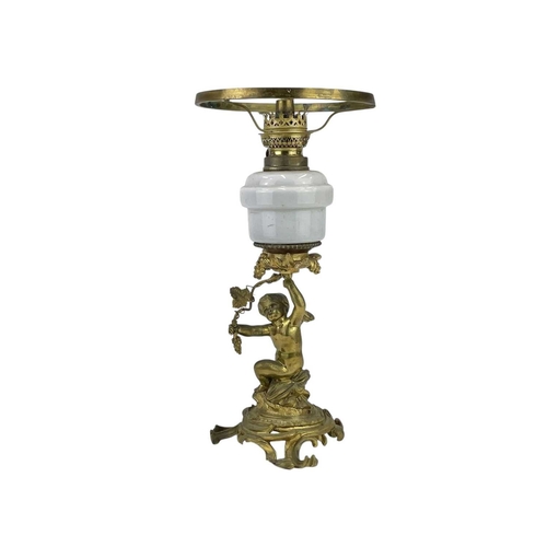 61 - A 19th century gilt brass cherub oil lamp. The opaque glass reservoir on a grape and vine base with ... 