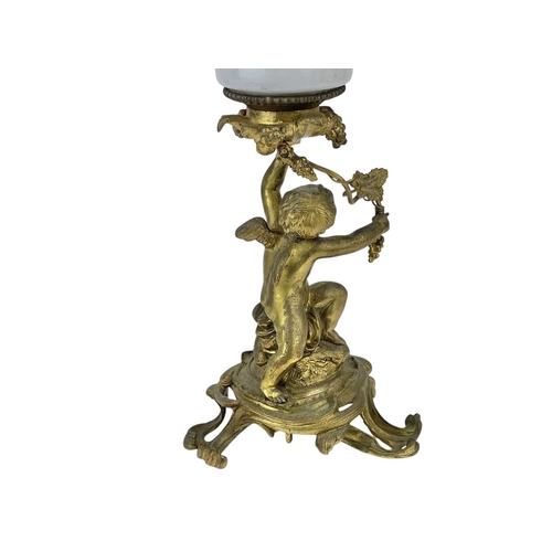 61 - A 19th century gilt brass cherub oil lamp. The opaque glass reservoir on a grape and vine base with ... 