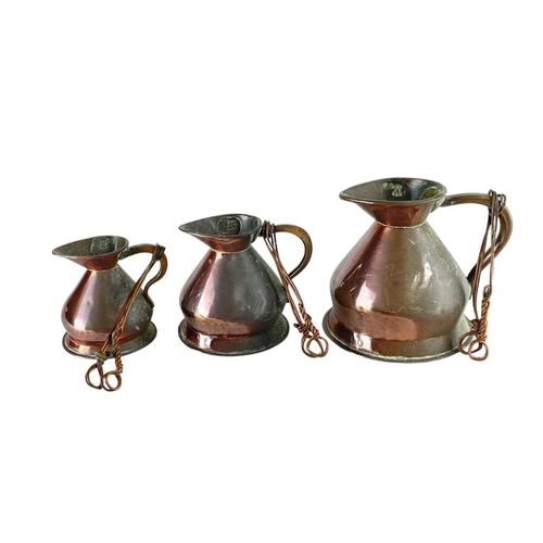 68 - A matched set of seven copper measure jugs. Late 19th/early 20th century, with official stamps, thre... 