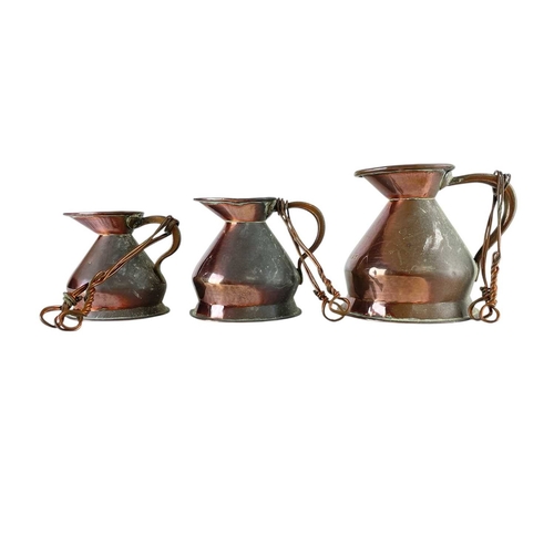 68 - A matched set of seven copper measure jugs. Late 19th/early 20th century, with official stamps, thre... 