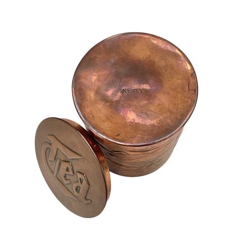 98 - A Newlyn cylindrical copper tea caddy Repousse decorated with two fish, on a matt ground, impressed ... 