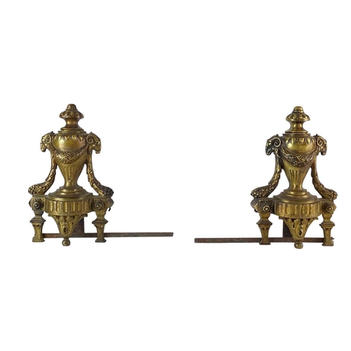 99 - A pair of French brass Chenets and fender rail. With ram's mask mounted urn finials, with a further ... 