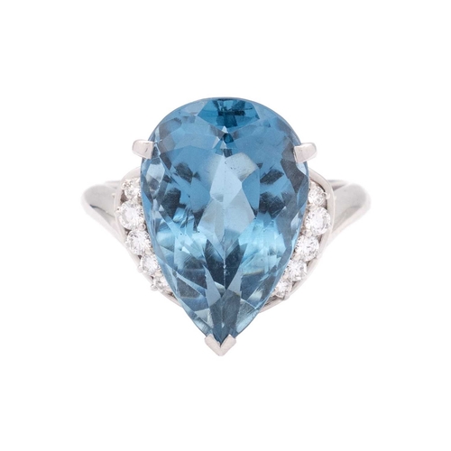 144 - A large Swiss blue topaz and diamond set dress ring in platinum. The pear-shaped mixed-cut topaz is ... 