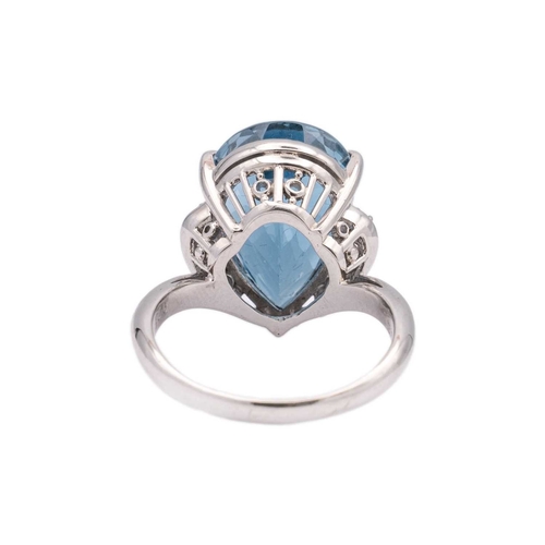 144 - A large Swiss blue topaz and diamond set dress ring in platinum. The pear-shaped mixed-cut topaz is ... 