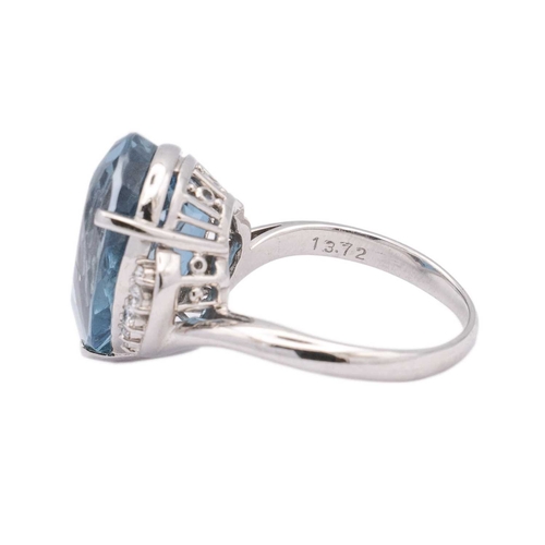 144 - A large Swiss blue topaz and diamond set dress ring in platinum. The pear-shaped mixed-cut topaz is ... 